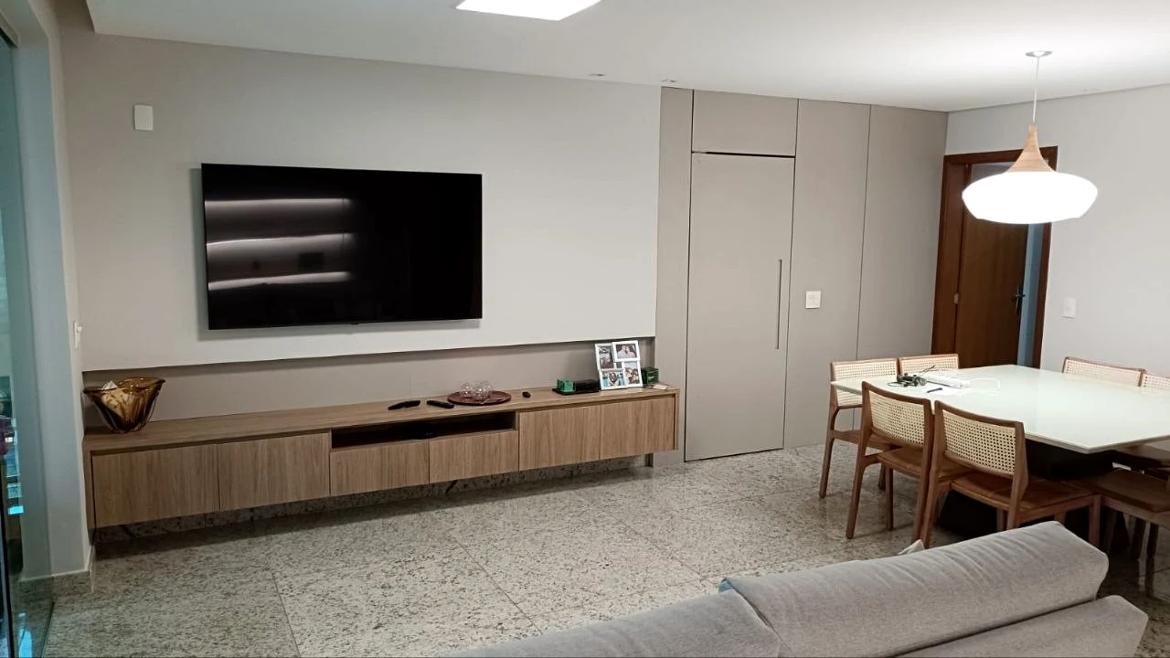 Sala integrada com painel, rack e mesa planejada